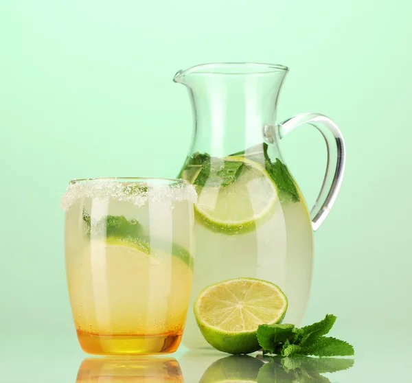 Limonade in Krug und Glas auf türkisfarbenem Hintergrund — Stockfoto