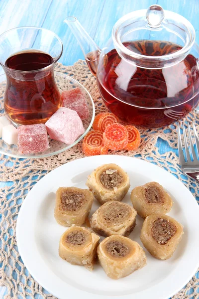Süße Baklava auf dem Teller mit Tee auf dem Tisch — Stockfoto