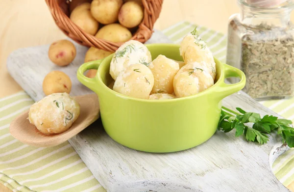 入札の若いジャガイモとサワー クリームとテーブルのクローズ アップの木製ボード上のパンのハーブ — ストック写真
