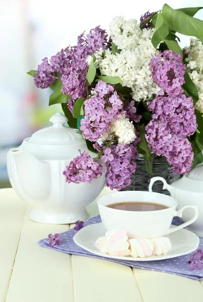 Složení s krásné květy, čajový servis na dřevěný stůl na světlé pozadí — Stock fotografie