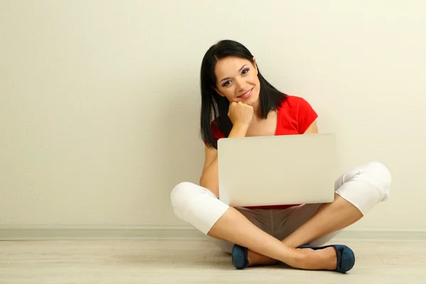 Mulher bonita sentada com notebook no quarto — Fotografia de Stock