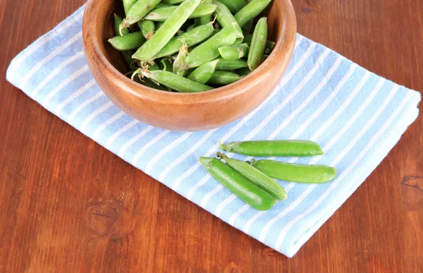 Zielony groszek w drewniane miski na serwetki na stół — Zdjęcie stockowe