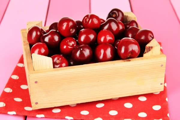 Kirschbeeren in Holzkiste auf Holztisch in Großaufnahme — Stockfoto