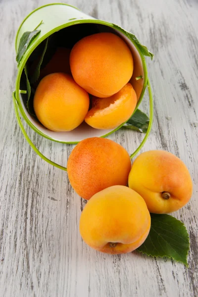 Aprikosen im Eimer auf Holztisch — Stockfoto