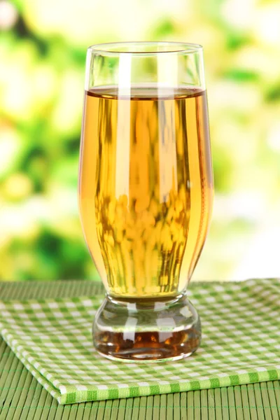 Copo de suco de maçã fresca na mesa no fundo brilhante — Fotografia de Stock