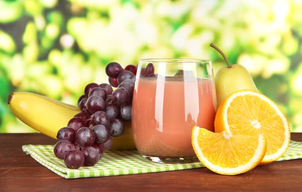 Glass of fresh juice on table on bright background — Stock Photo, Image