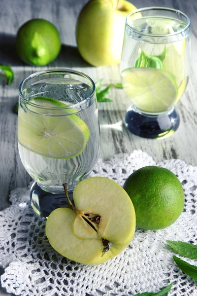 Verres de cocktail à la lime sur serviette sur table en bois léger — Photo