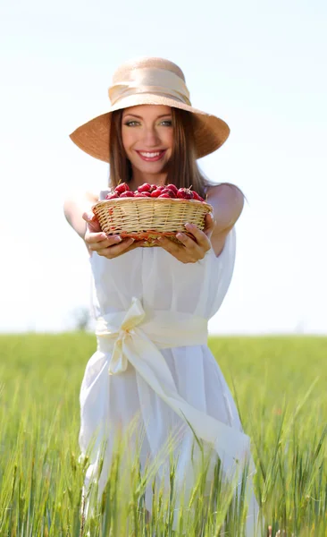 Portret van mooie jonge vrouw met bessen in het veld — Stockfoto