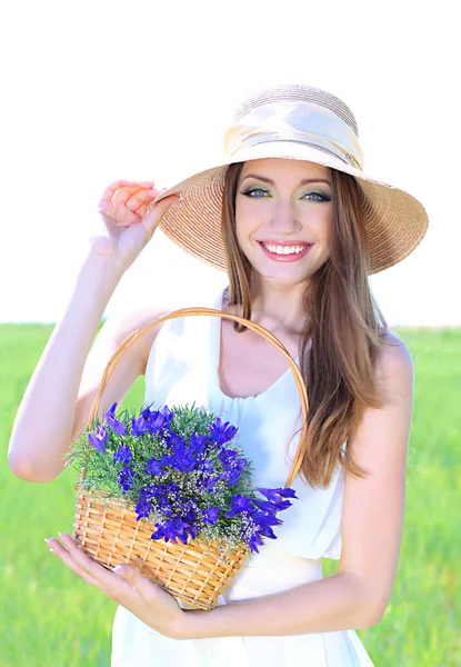 Porträtt av vacker ung kvinna med blommor i fältet — Stockfoto