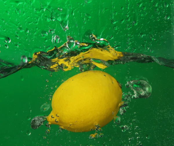 多汁柠檬在水之下，绿色背景 — 图库照片