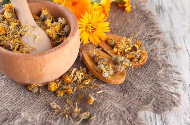 harç ahşap zemin üzerine calendula taze ve kuru çiçekler