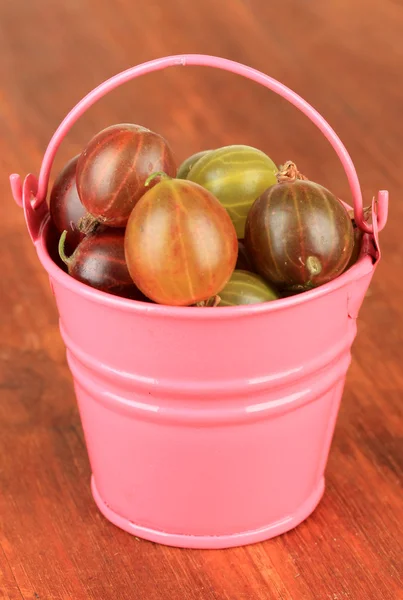 Fresh gooseberries in bucket on table close-up — Stock Photo, Image