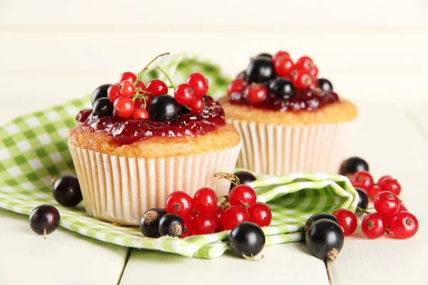 Tasty muffins with berries on white wooden table — Stock Photo, Image