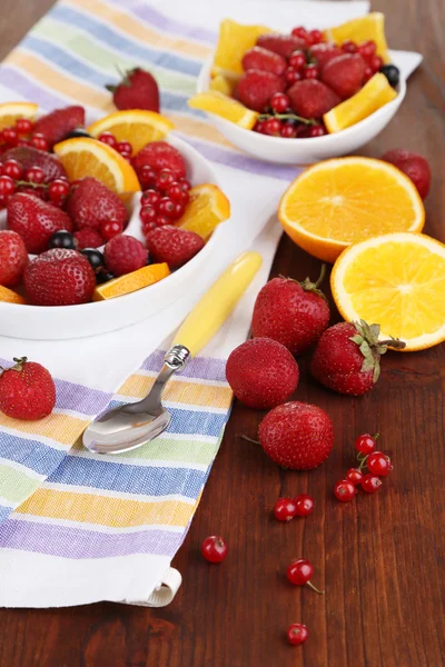 Ensalada de frutas útil en platos sobre mesa de madera de cerca — Foto de Stock