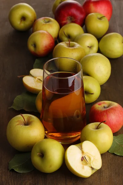 Användbara äppeljuice med äpplen runt på träbord — Stockfoto