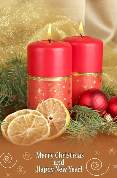 Two candles and Christmas decorations, on golden cloth background — Stock Photo, Image