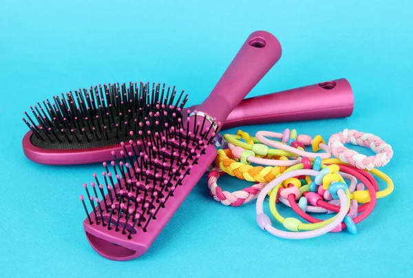 Scrunchies, cepillo y cabello - clip sobre un fondo azul —  Fotos de Stock