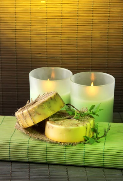 Hand made soap and candles on bamboo mat background — Stock Photo, Image