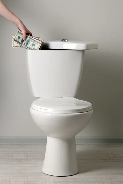 手隐藏在厕所水箱在浴室里的钱 — 图库照片