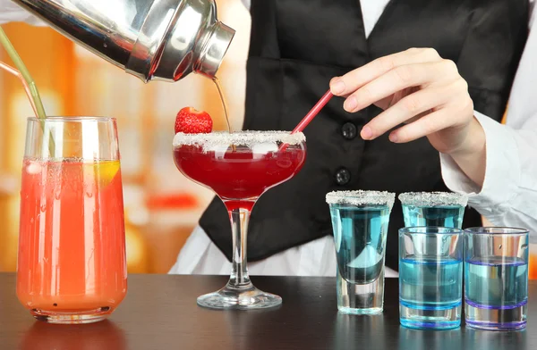 Barmen hand met gieten cocktail shaker in glas, op lichte achtergrond — Stockfoto