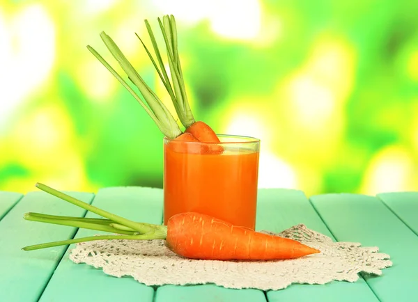 Gelas jus wortel, di atas meja kayu berwarna dengan latar belakang cerah — Stok Foto