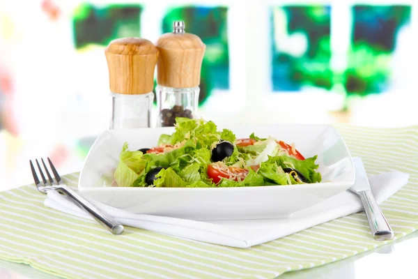 Leichter Salat auf Teller auf Serviette auf Fensterhintergrund — Stockfoto