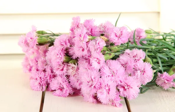 Muchos pequeños dientes rosados sobre fondo de madera — Foto de Stock