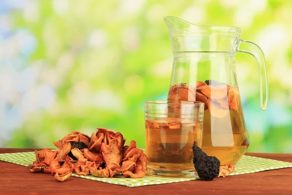 Assorted dried fruits and compote of dried fruits on wooden table on natural background — Stock Photo, Image