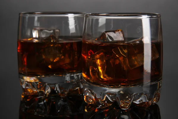 Brandy glasses with ice on grey background — Stock Photo, Image