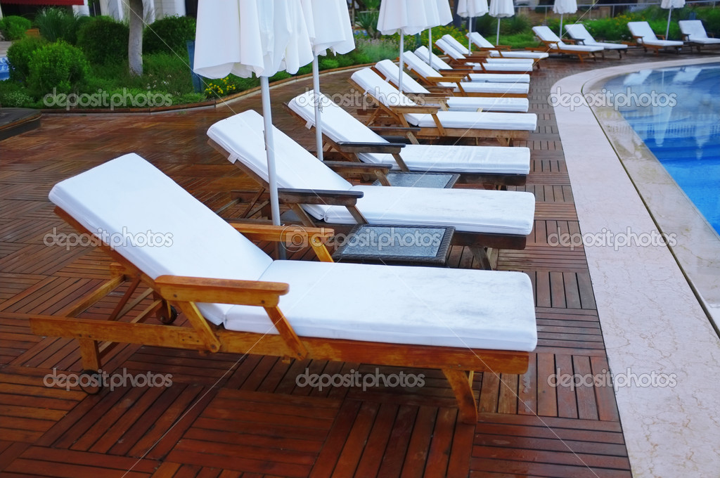 Lounge sunbed in swimming pool Stock Photo by ©belchonock 28091413