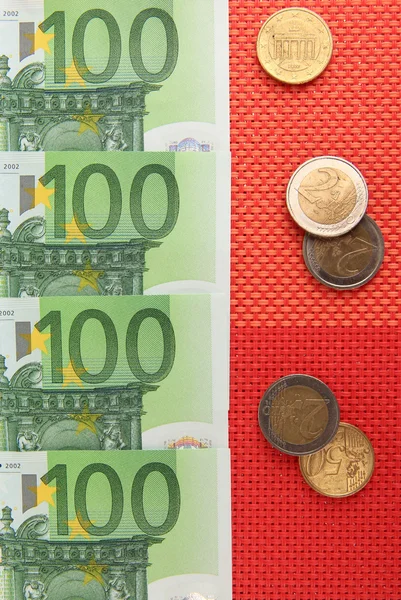 Billetes en euros y céntimos en euros sobre fondo rojo — Foto de Stock