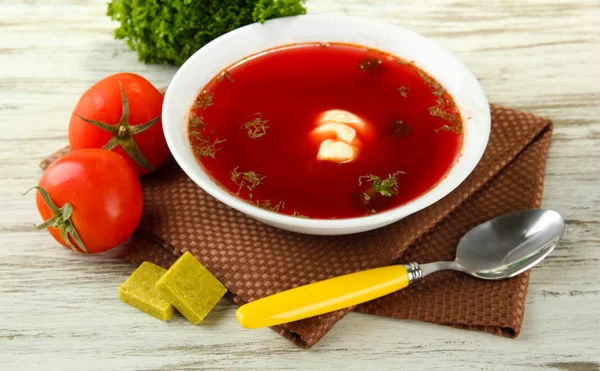 Kom soep met bouillonblokjes op houten tafel — Stockfoto