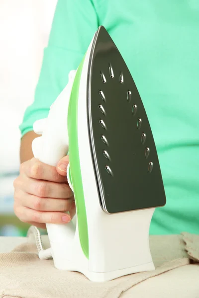 Woman's hand ironing clothes, on bright background — Stock Photo, Image