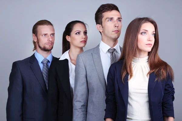 Equipe de negócios em fila no fundo cinza — Fotografia de Stock