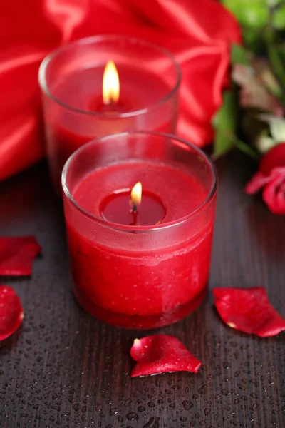 Bella candela rossa romantica con fiori, da vicino — Foto Stock