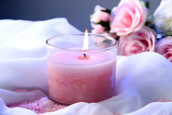 Bella candela con fiore su panno bianco, primo piano — Foto Stock