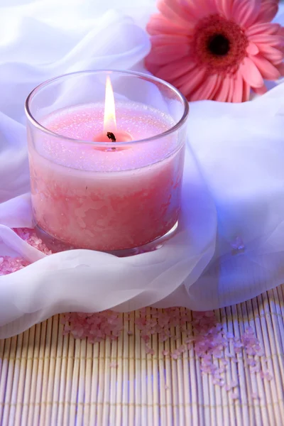 Beautiful candle with flower on white cloth, close up — Stock Photo, Image