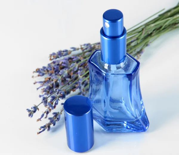 Perfume em garrafa e lavanda isolado em branco — Fotografia de Stock