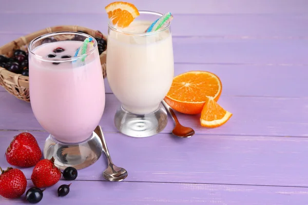Pyszne koktajle mleczne z orange i blackberry na drewniany stół szczegół — Zdjęcie stockowe