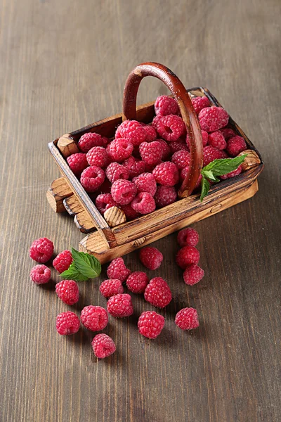 Ripe sweet raspberries in basket on wooden background — Stock Photo, Image