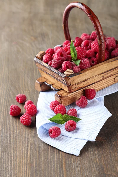 Ripe sweet raspberries in basket on wooden background — Stock Photo, Image