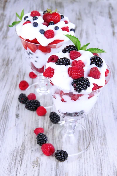 Yogurt naturale con bacche fresche su sfondo di legno — Foto Stock