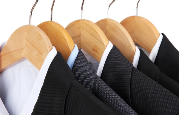 Suits with shirts on hangers on light background — Stock Photo, Image