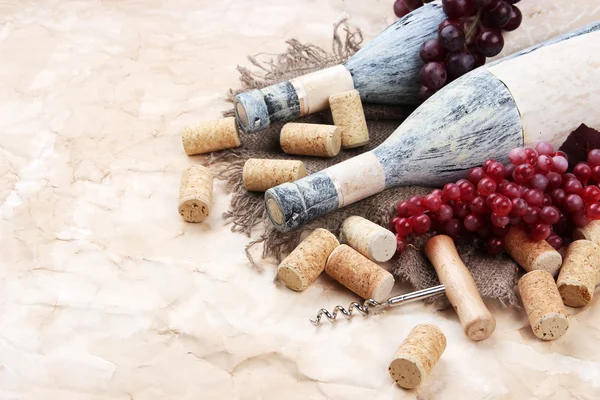 Viejas botellas de vino, uvas y corchos sobre papel viejo — Foto de Stock