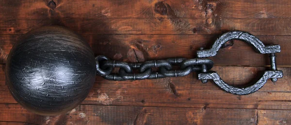 Ball and chain on wooden background — Stock Photo, Image