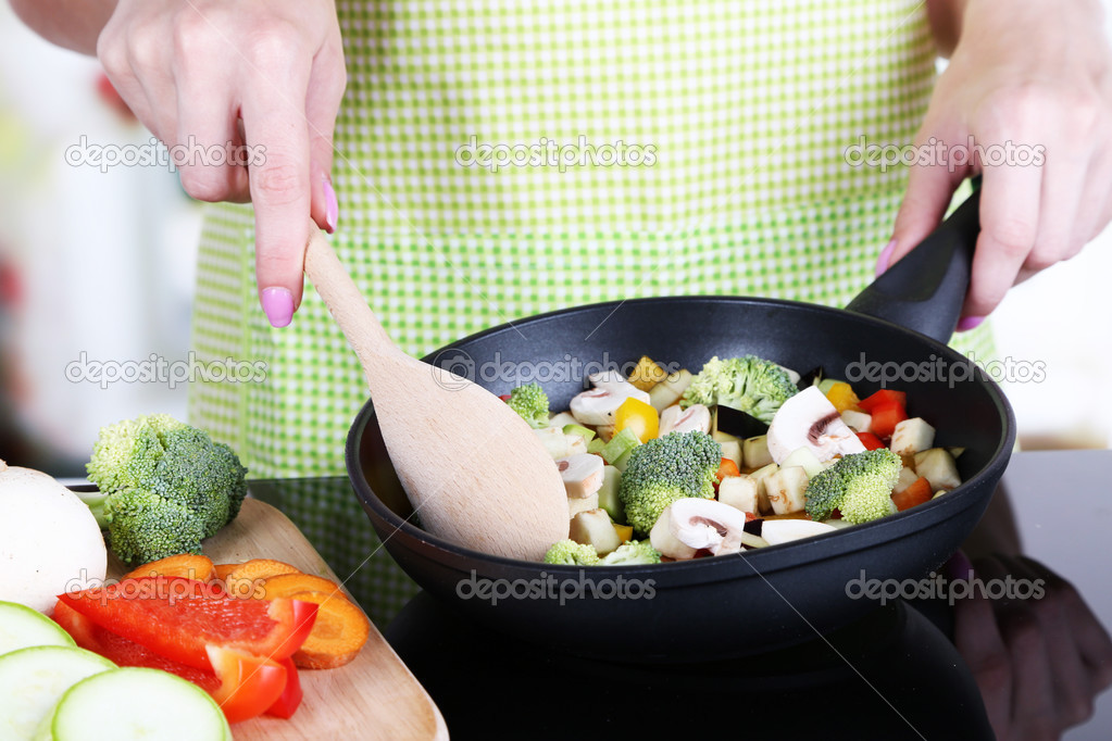 Hands cooking vegetable ragout in pan in kitchen