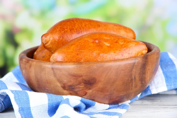 Vers gebakken pasteitjes, in houten kom, op houten tafel, op lichte achtergrond — Stockfoto