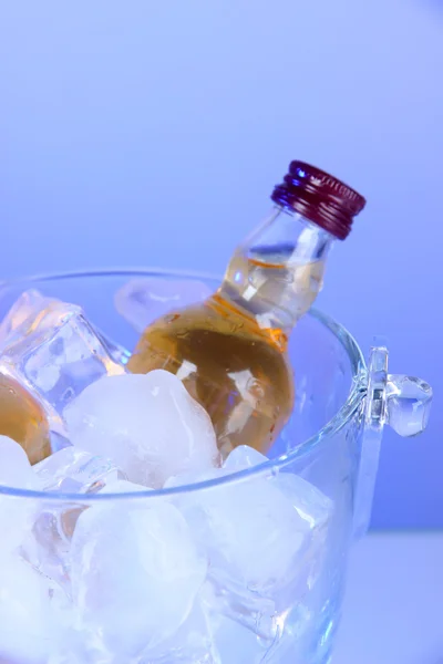 Minibar botellas en cubo con hielo, sobre fondo de color — Foto de Stock