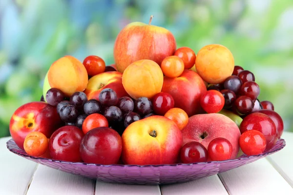 Surtido de frutas jugosas sobre mesa de madera, sobre fondo brillante —  Fotos de Stock