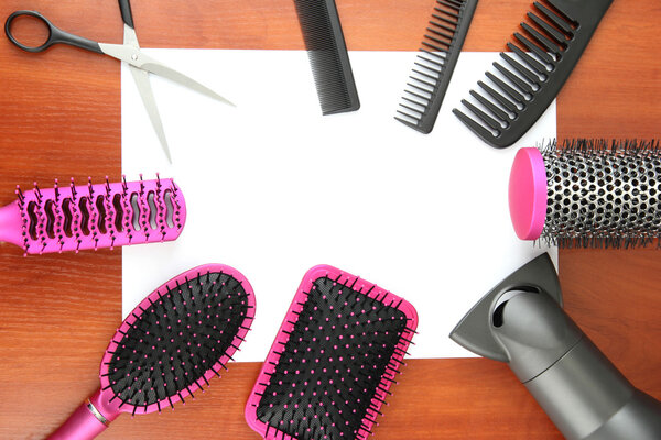 Comb brushes, hairdryer and cutting shears,on wooden background